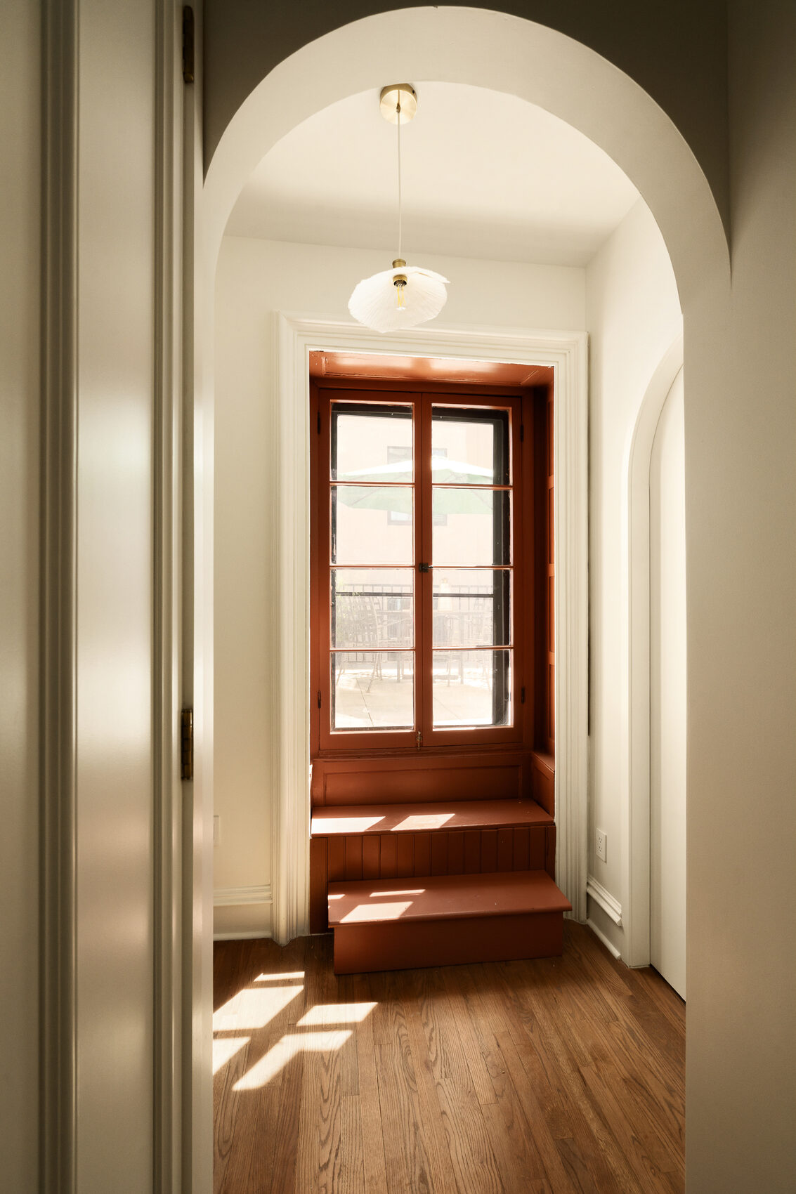 A paneled wood door framing the arched hallway at № 428 West 20th Street